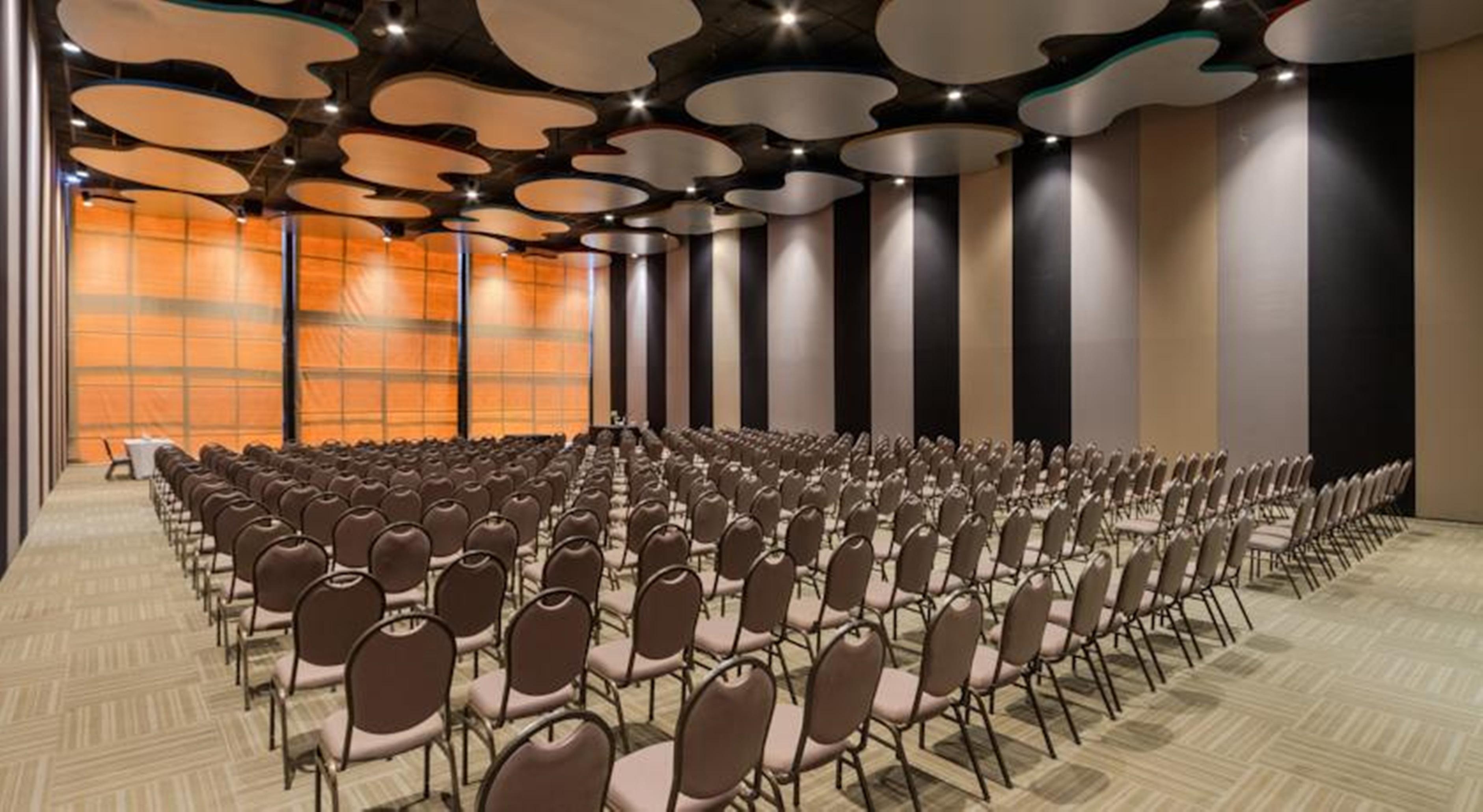 Royal Tulip Brasilia Alvorada Hotel Luaran gambar The photo shows a large conference or event space filled with numerous empty chairs arranged in rows. The chairs have a simple design, with cushioned seats and backs. The walls of the room are decorated with a combination of dark and light tones, and